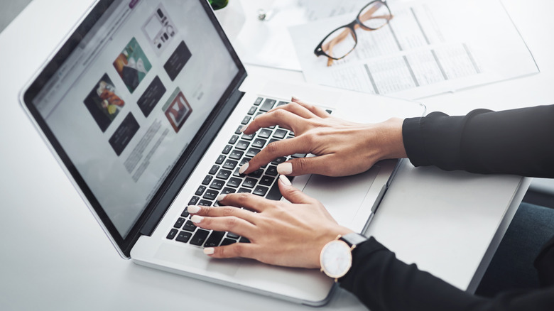 Close up person working on laptop