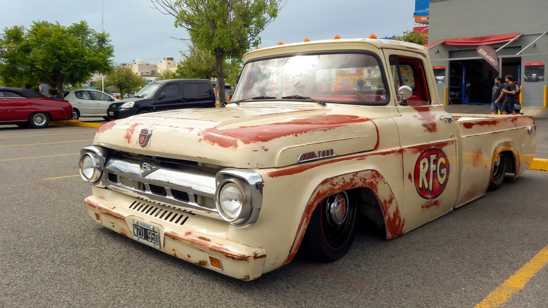 A Ford F-100 custom lowrider with rust paint work