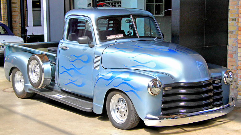 Lowrider pickup truck front 3/4 shot in silver with blue flames