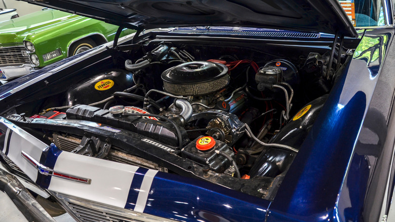 American muscle car with open hood displaying a V8 engine