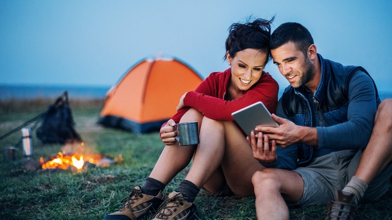 Couple using a tablet while camping