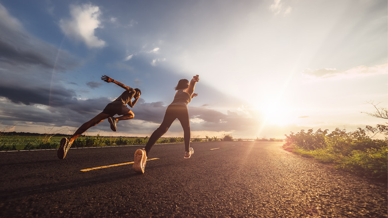 two runners sprinting down road