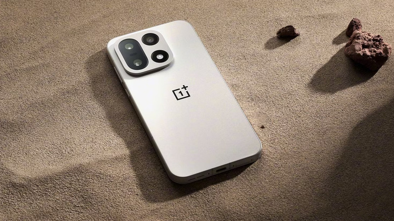 The OnePlus 15 against a sandy background