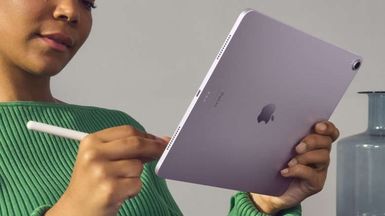 A person using a purple 13-inch iPad Air with an Apple Pencil