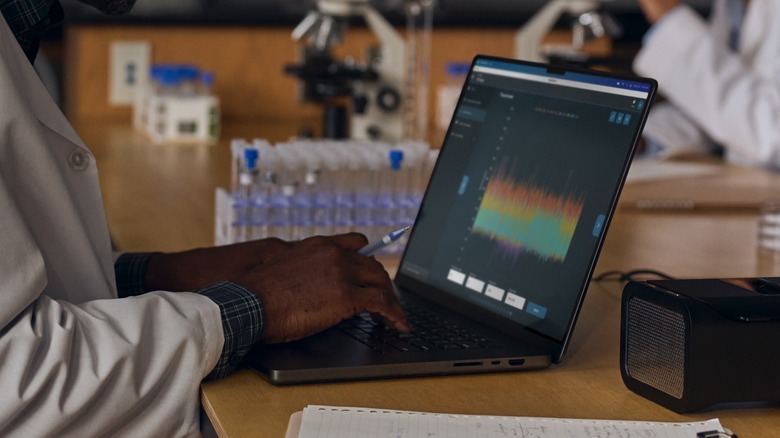A researcher using an Apple MacBook Pro for their work