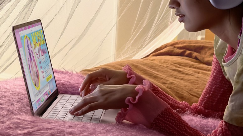 A person using the MacBook Neo on their bed