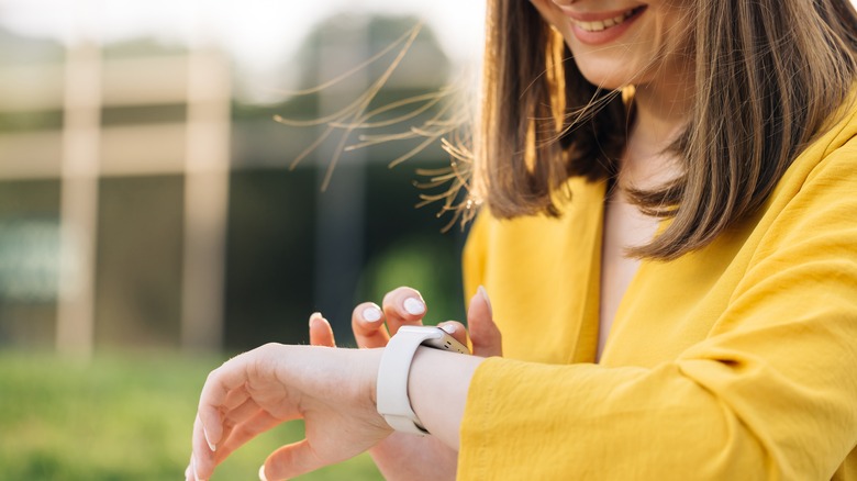 woman smiling, using her Apple Watch