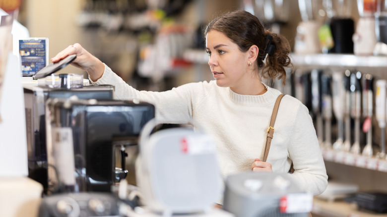 A person inspecting appliances in a store.
