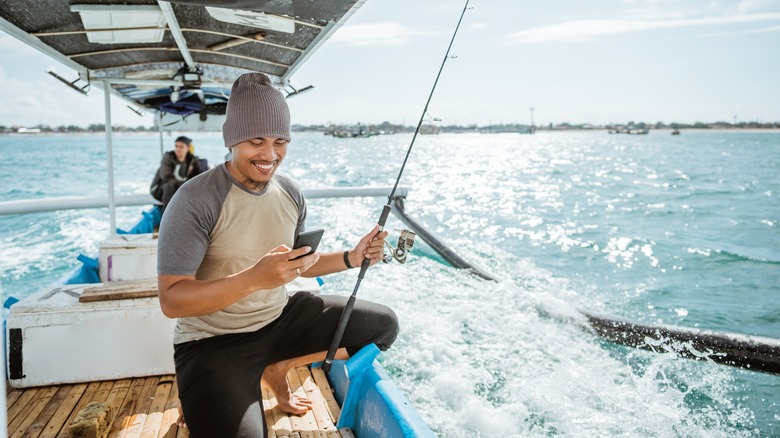 Fisherman holding smartphone