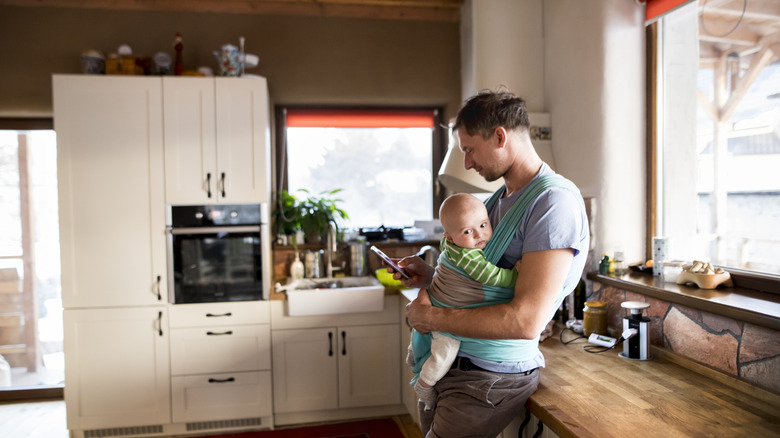 man holding baby with phone