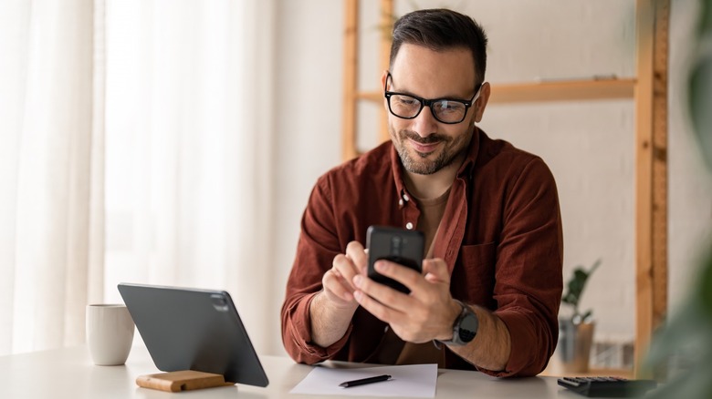 Man using a phone and a tablet