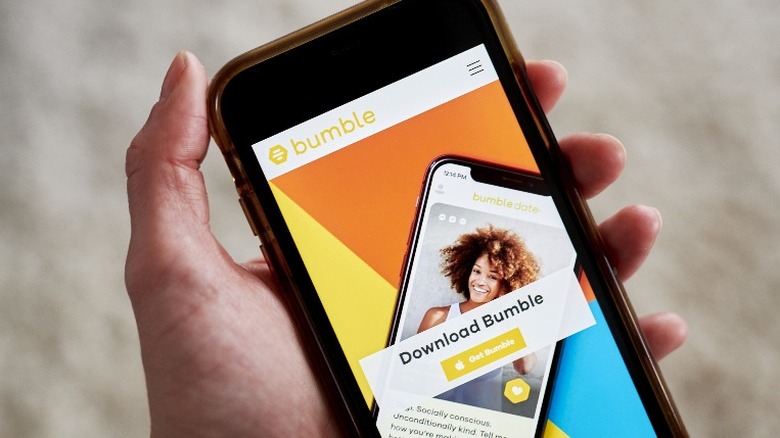 person holding phone with bumble app