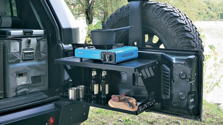 A suntop Tailmesa tailgate table mounted on a black Jeep