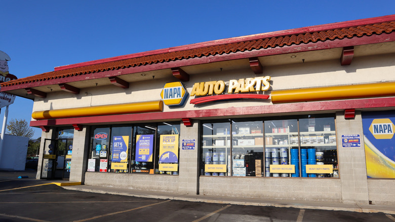 A NAPA Auto Parts storefront, its front windows filled with car parts and merchandise.