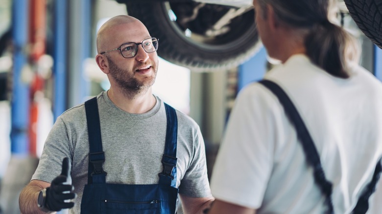 A mechanic speaking to another mechanic