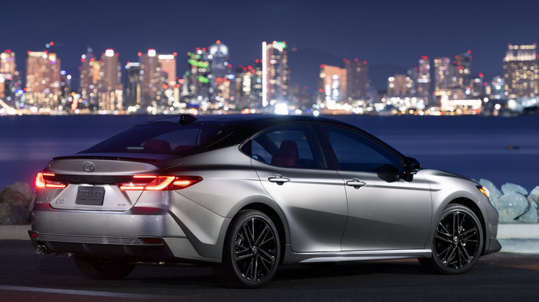 Rear 3/4 view of Toyota Camry at night in seaside setting
