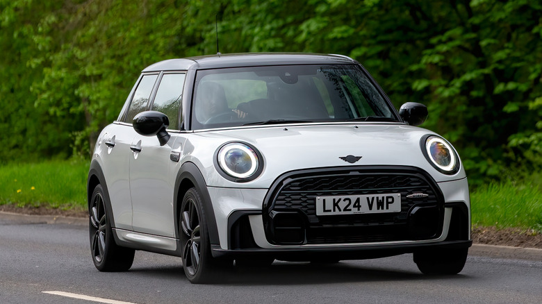 White Mini Cooper car driving on a British country road