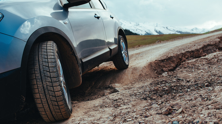 Blue car driving over rugged terrain