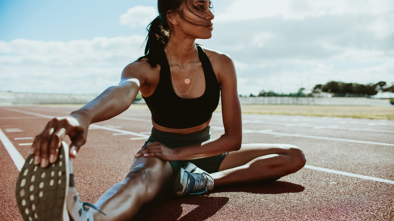 runner stretching on track