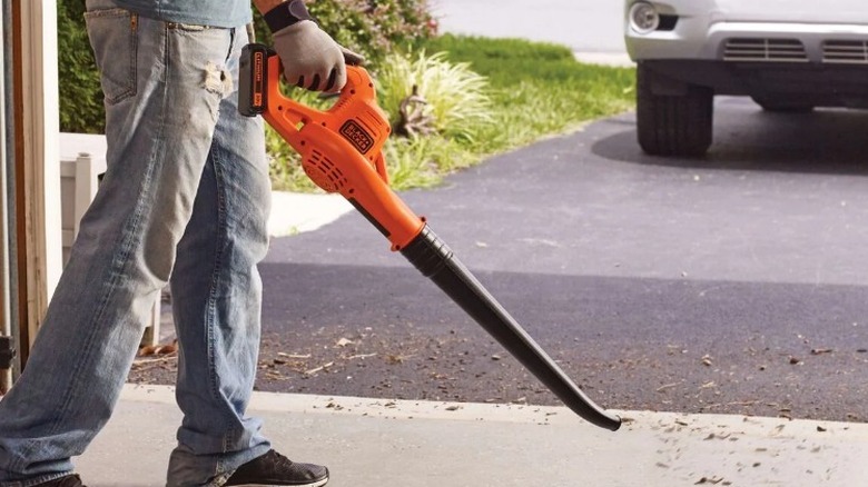 Person cleaning garage with Black and Decker blower