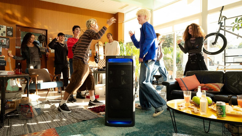 People in a messy room surrounding the Sony ULT Tower 9.