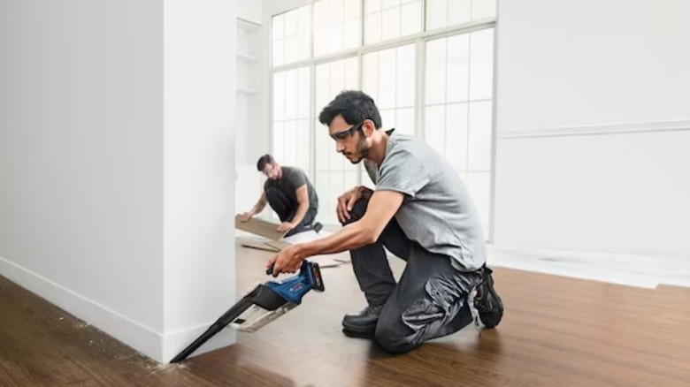 Man using Bosch Professional Cordless 0.5 Gallon 1 Horsepower Vacuum Cleaner on floor