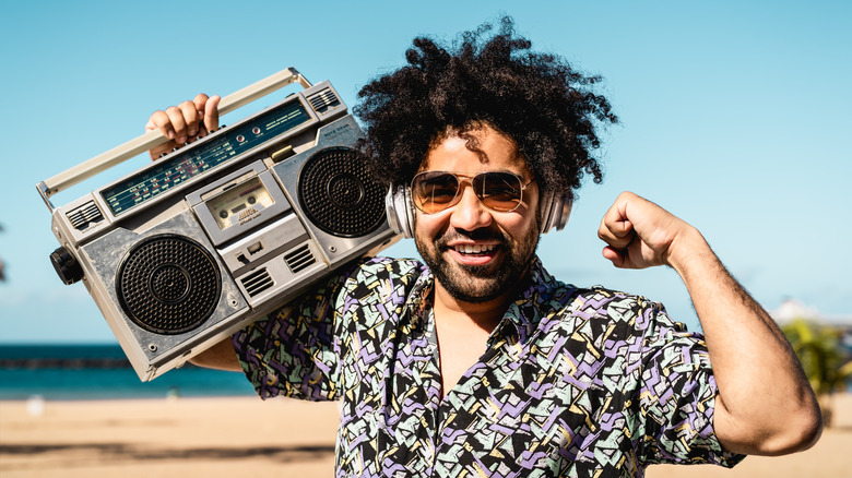 Someone posing with a silver boombox.