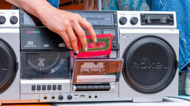 A silver Roxel Camden boombox being loaded with a tape.