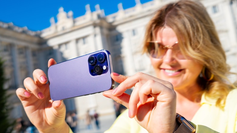 Woman taking picture with iPhone