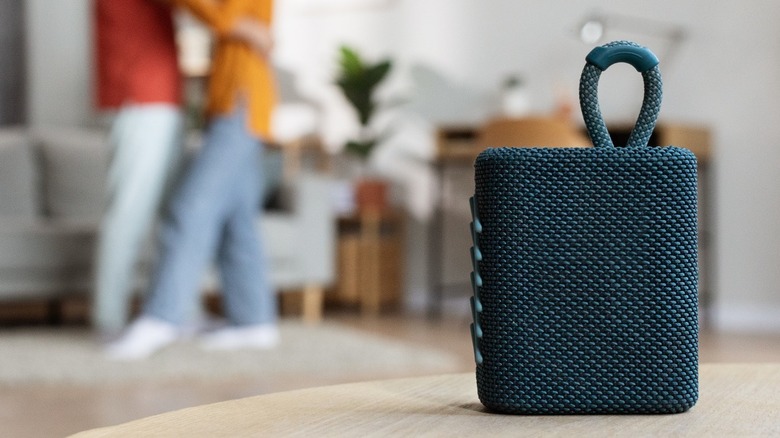 couple dancing behind a portable Bluetooth speaker