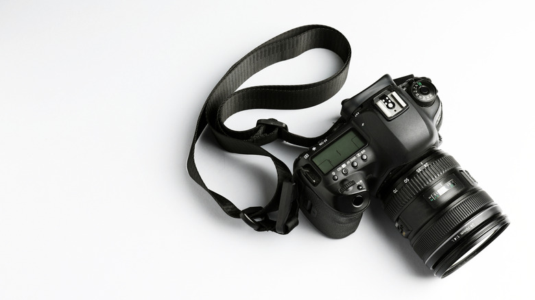 A professional camera with a strap attached to it