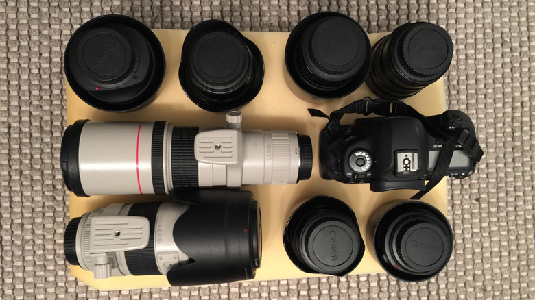 A camera and different types of lenses around it