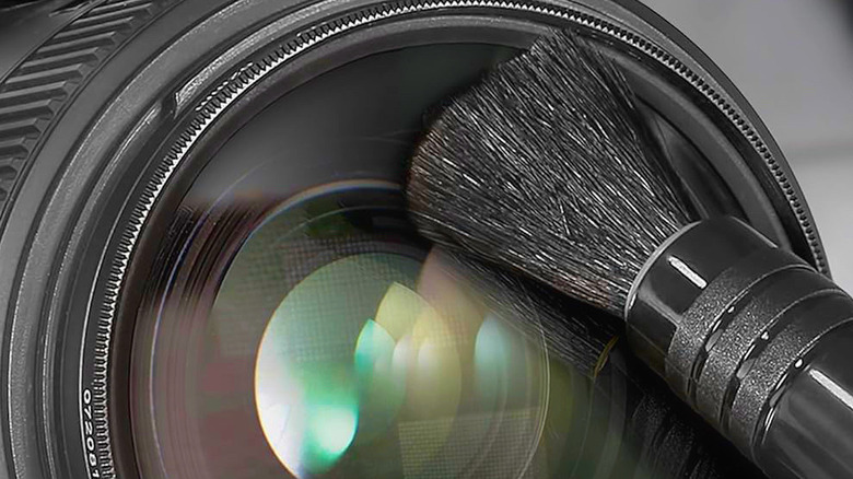 A soft brush delicately cleaning a lens.