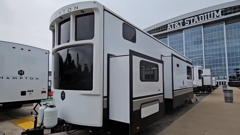 Crossroads Hampton RV with sides extended, parked in stadium parking, front-left 3/4 view