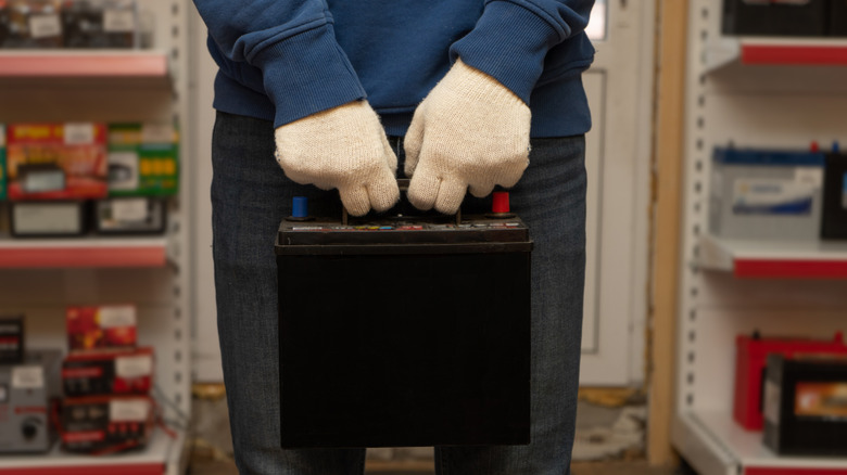Person holding a car battery