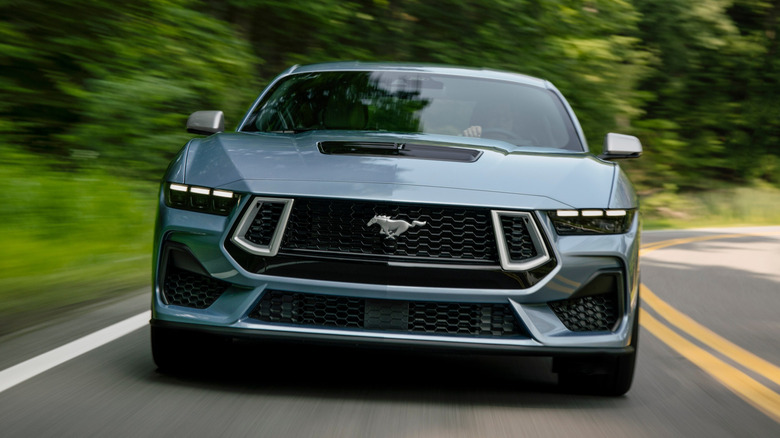 Front view of 2025 Ford Mustang driving on country road.