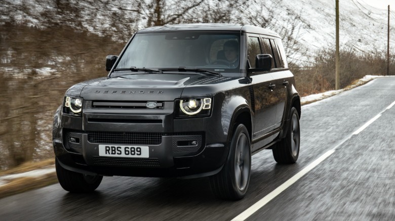 Black Defender 110 driving on a snowy road