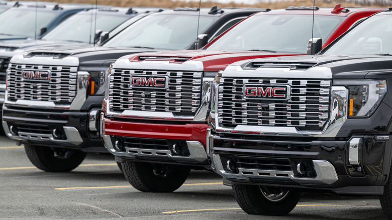 Front view of GMC Sierra pickups lined up on dealership lot.
