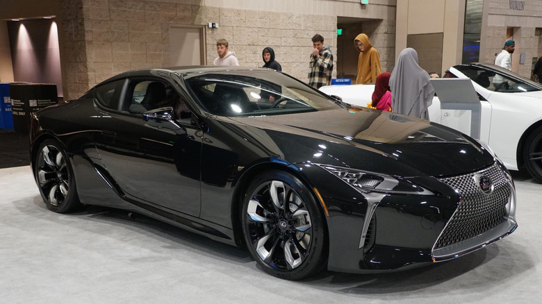 A brand new 2024 Lexus LC 500 car, in black, displayed inside a showroom