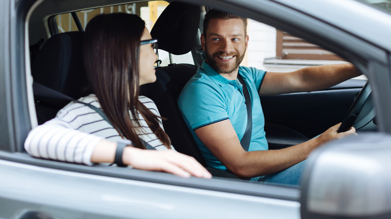 Driver and passenger making eye contact in a car