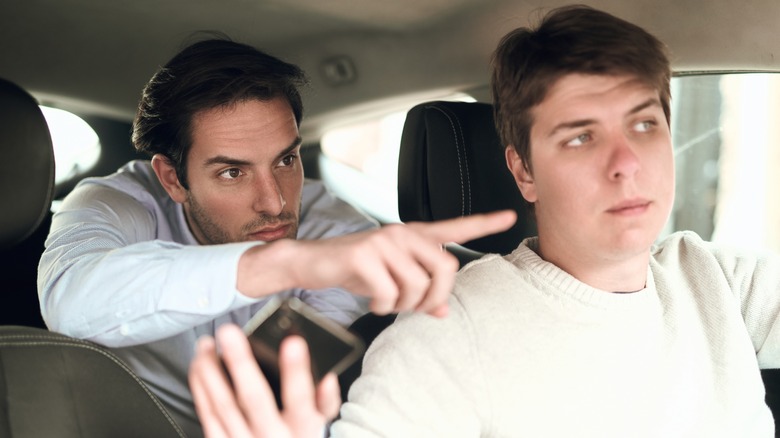 Passenger in the backseat directing the driver