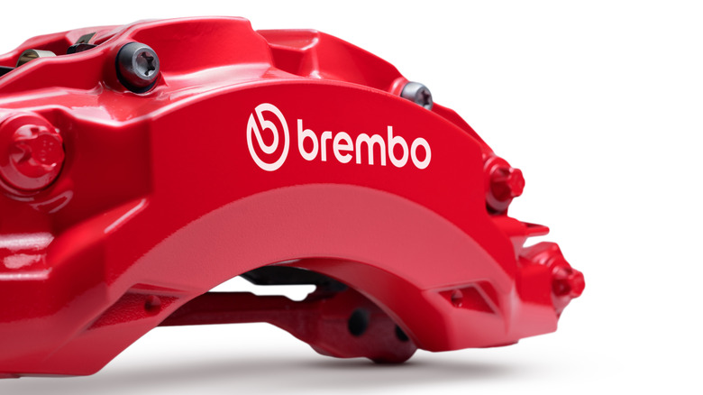 Close up view of red Brembo six-piston brake caliper.