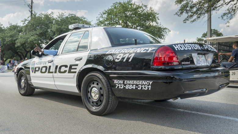 Rear 3/4 view of Ford Crown Victoria police car driving in parade.