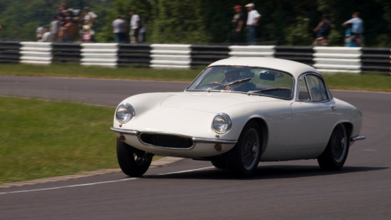 White classic car cornering on a race track.