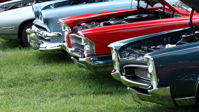 Colorful American classic muscle cars parked next to each other on a lawn.