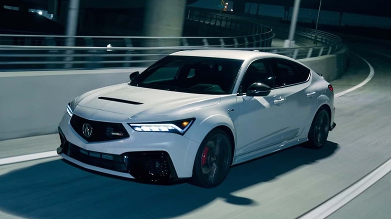2025 Acura Integra Type S driving on highway off-ramp at night, front left 3/4 view