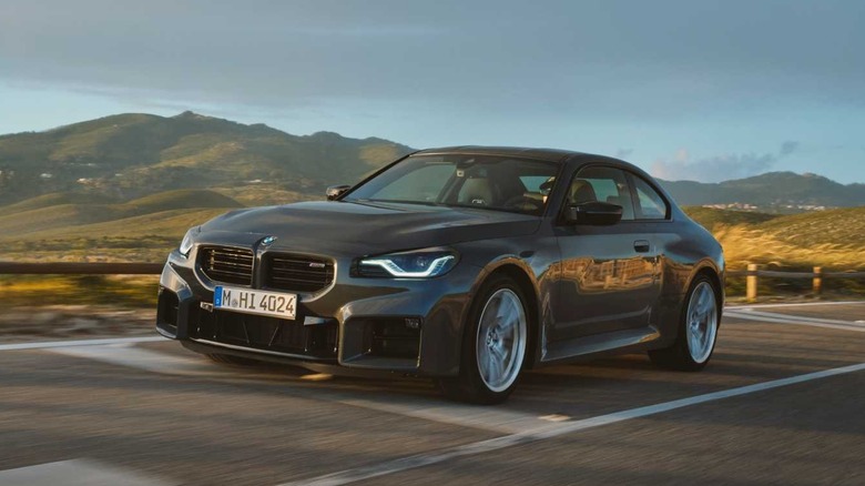 2025 BMW M2 driving on coastal road, front left 3/4 view