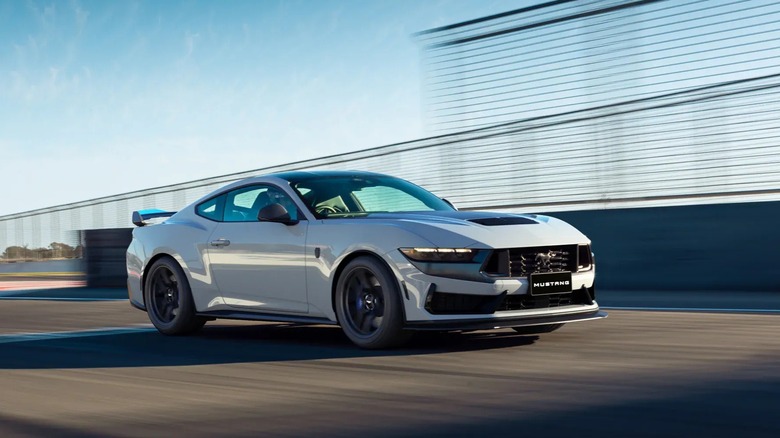 Ford Mustang Dark Horse driving on racetrack at speed, front right 3/4 view