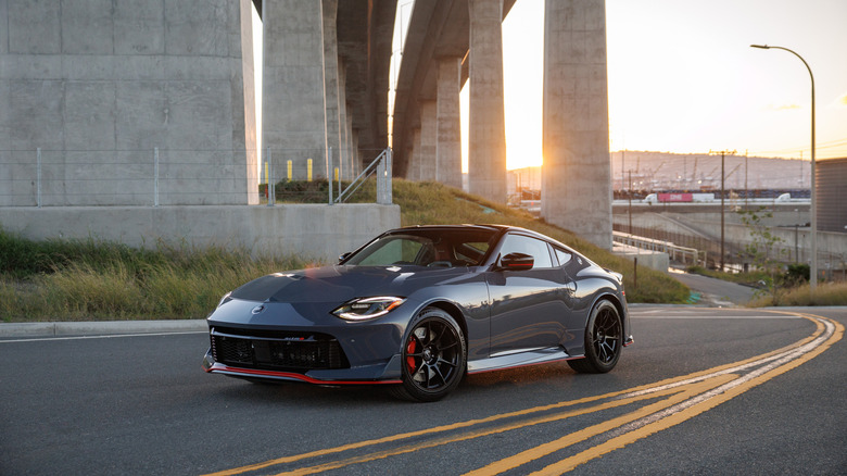 2027 Nissan Z NISMO on a road below an interstate, front left 3/4 view