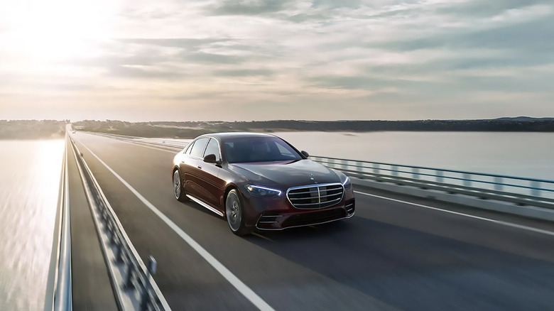 A dark red 2025 Mercedes-Benz S-Class driving